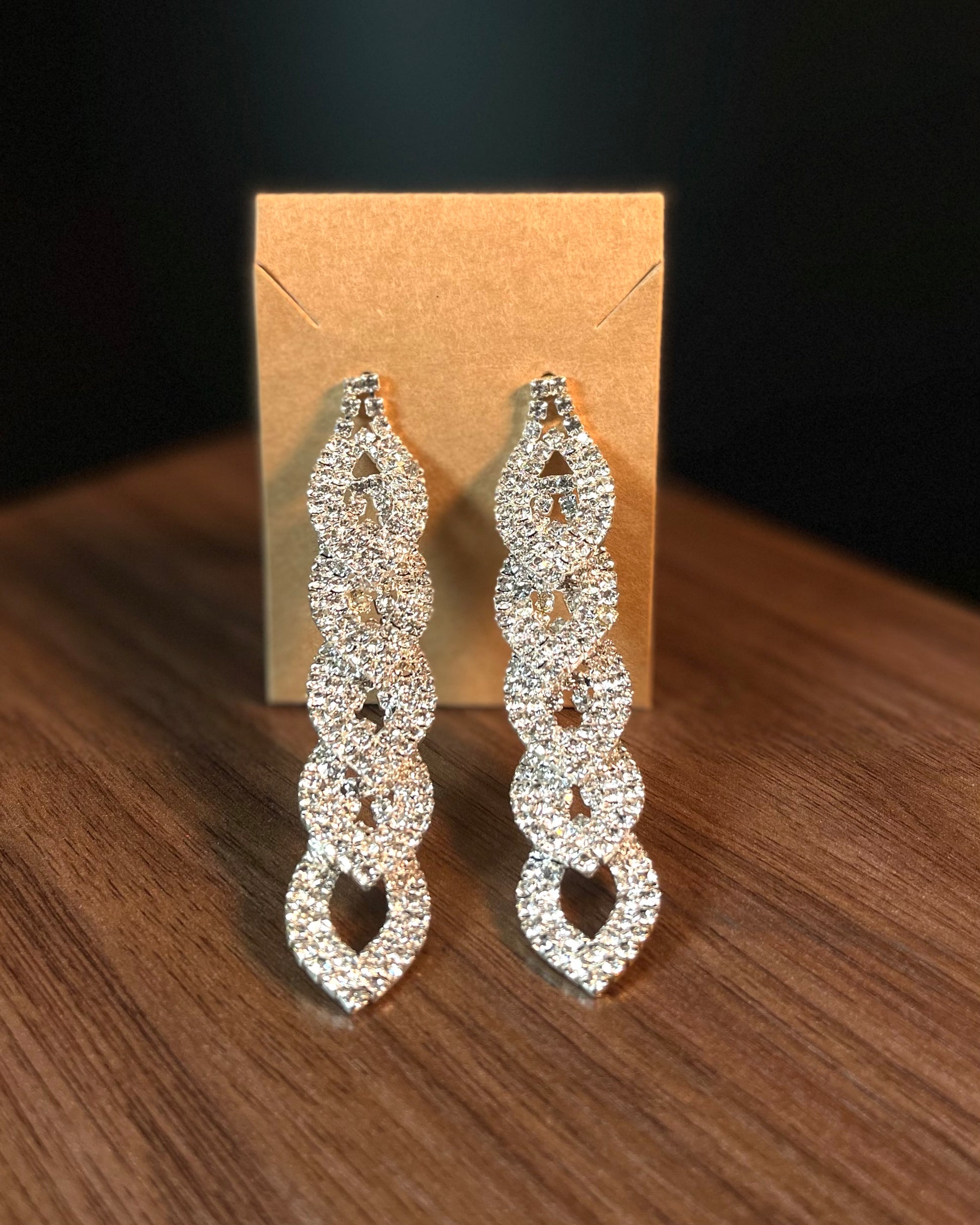 Long silver rhinestone pavé interlocking link drop earrings on kraft card display — DubyAllure Lumière Cascade