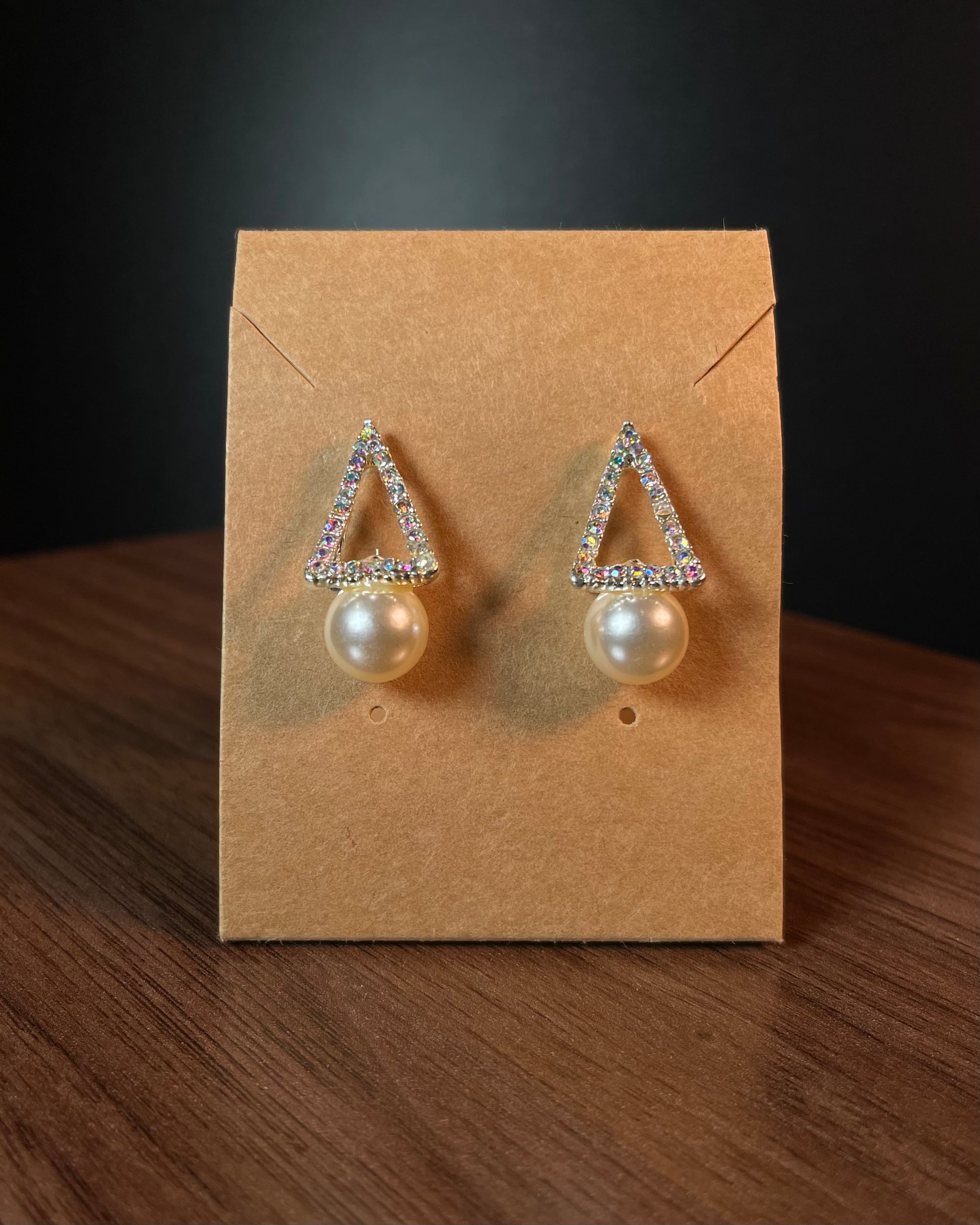 Silver aurora borealis crystal triangle stud earrings with large white pearl drop on black beaded background — Duby Allure Prisme
