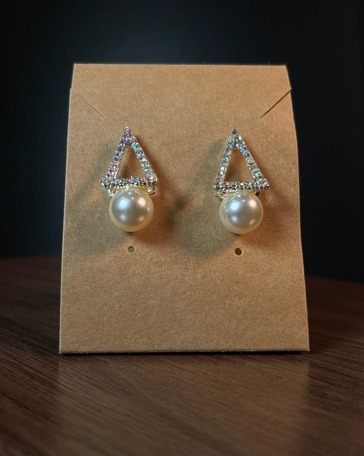 Silver aurora borealis crystal triangle stud earrings with large white pearl drop on black beaded background — Duby Allure Prisme