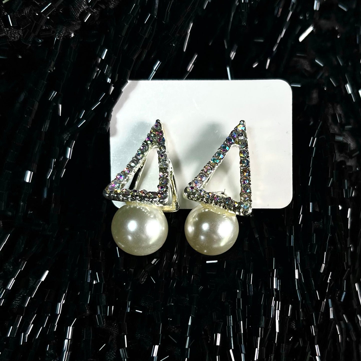 Silver aurora borealis crystal triangle stud earrings with large white pearl drop on black beaded background — DubyAllure Prisme