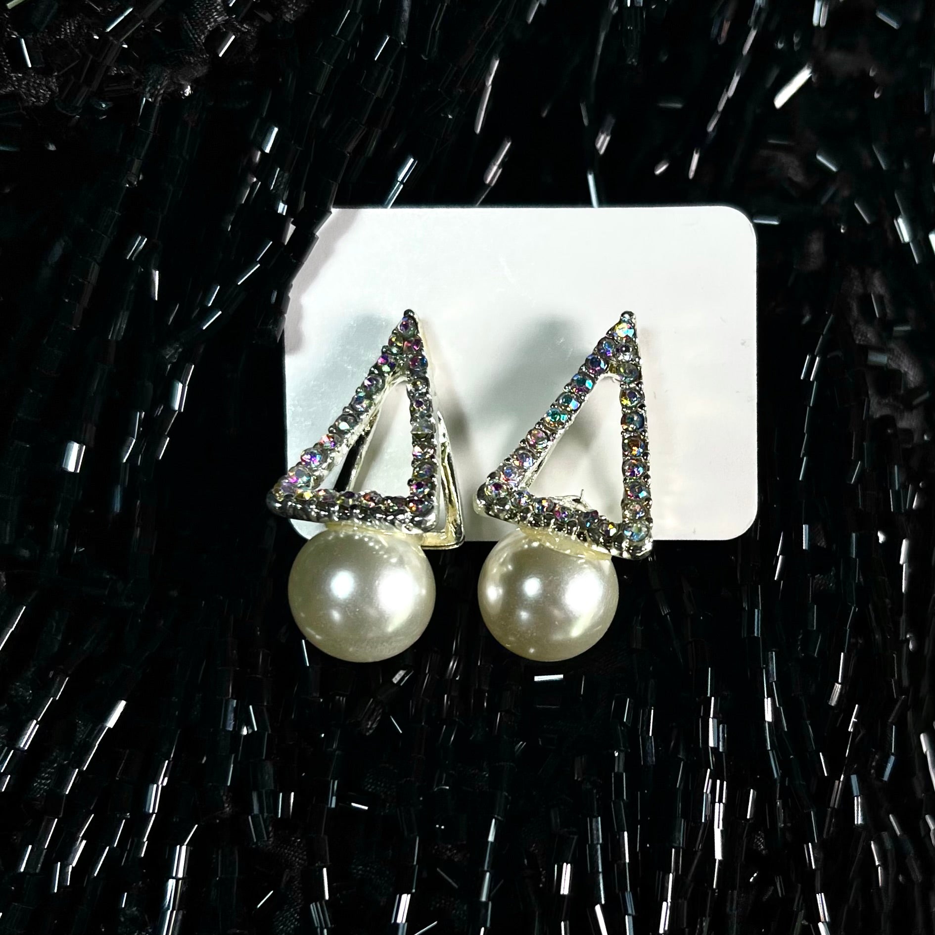 Silver aurora borealis crystal triangle stud earrings with large white pearl drop on black beaded background — DubyAllure Prisme