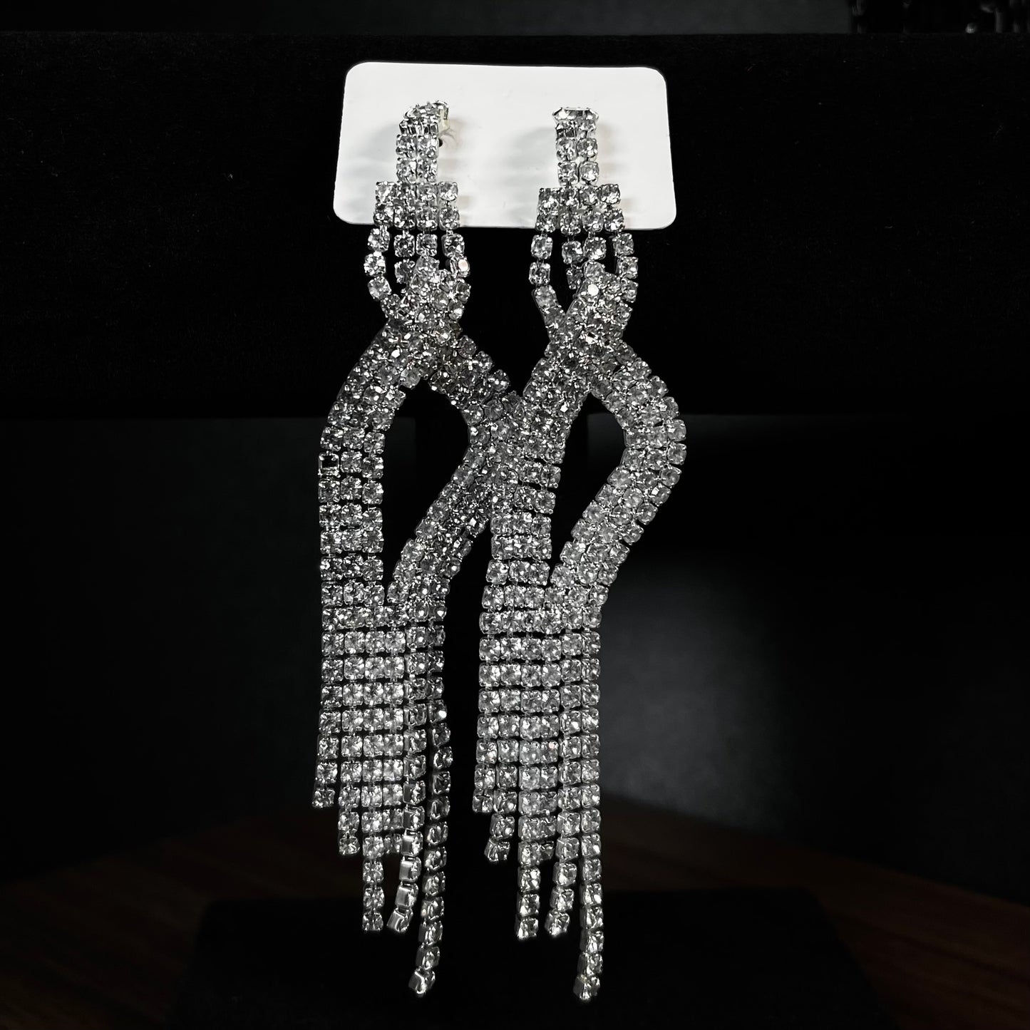 Long silver crystal fringe chandelier earrings with knotted rhinestone top and cascading tassel strands on white card display — Duby Allure Velvet Rain