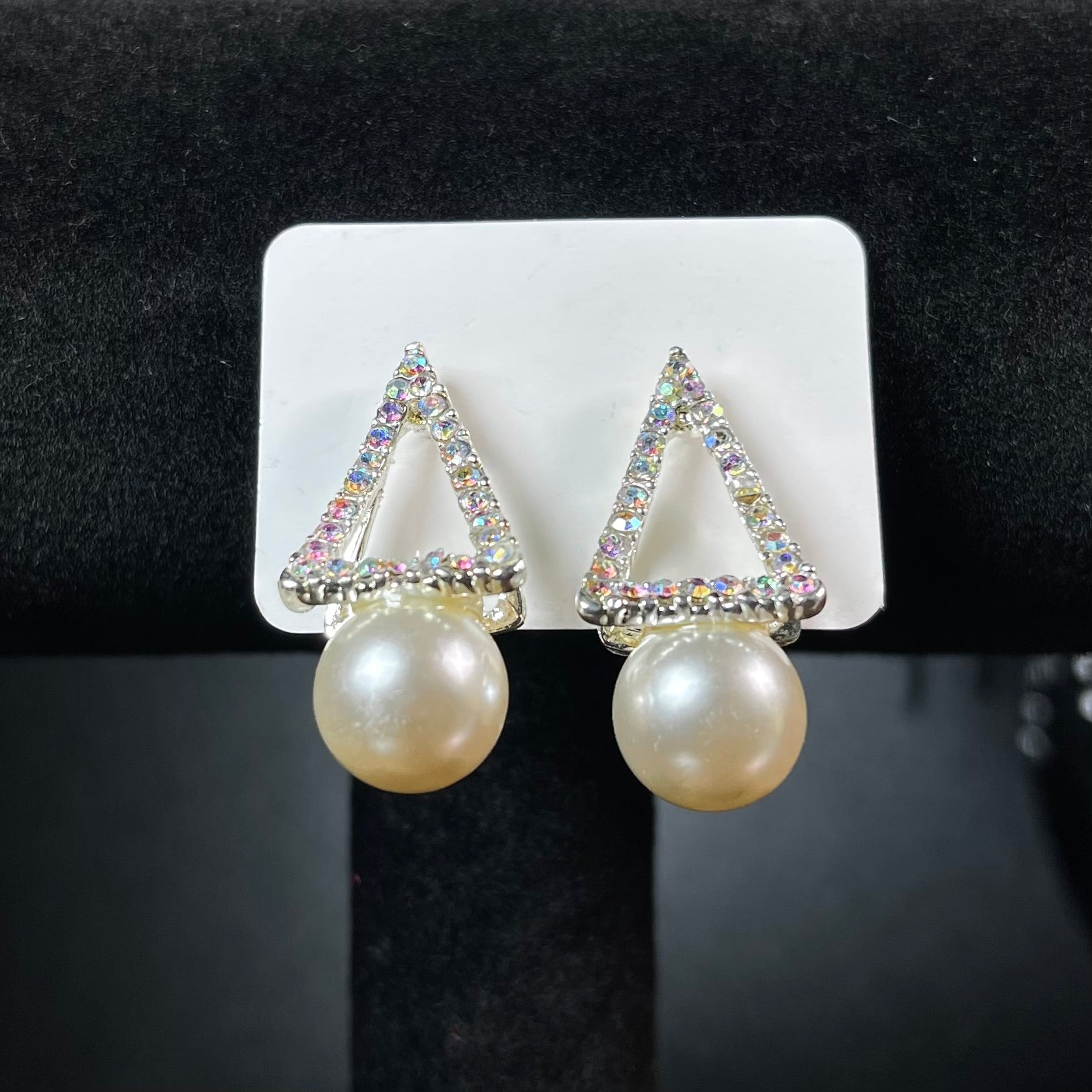 Silver aurora borealis crystal triangle stud earrings with large white pearl drop on black beaded background — Duby Allure Prisme