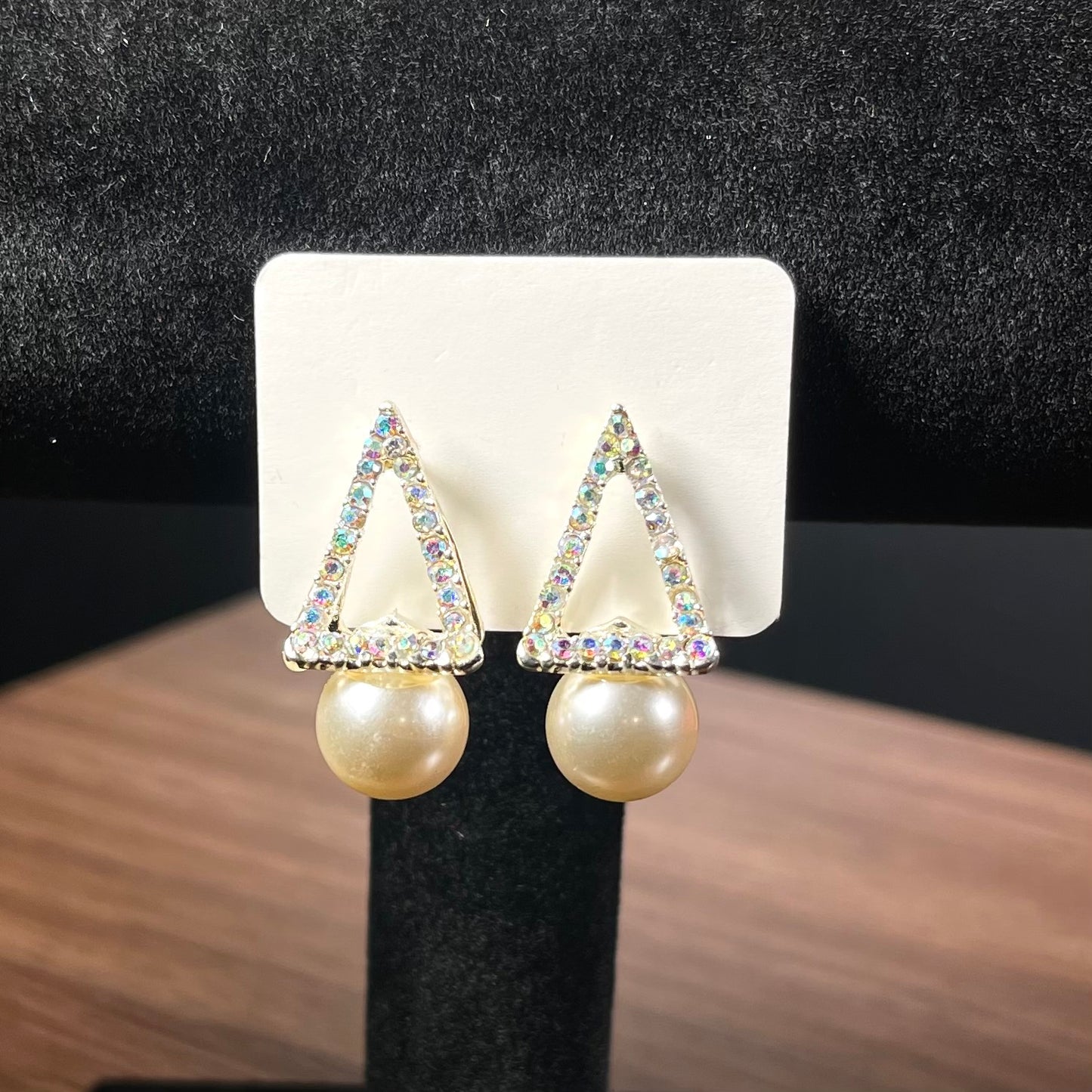 Silver aurora borealis crystal triangle stud earrings with large white pearl drop on black beaded background — Duby Allure Prisme